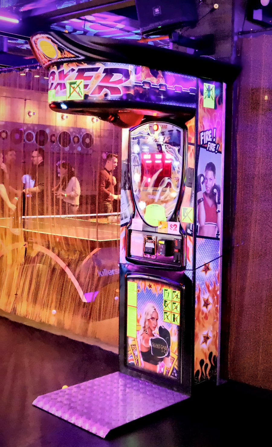 Boxer punching arcade machine under neon lights