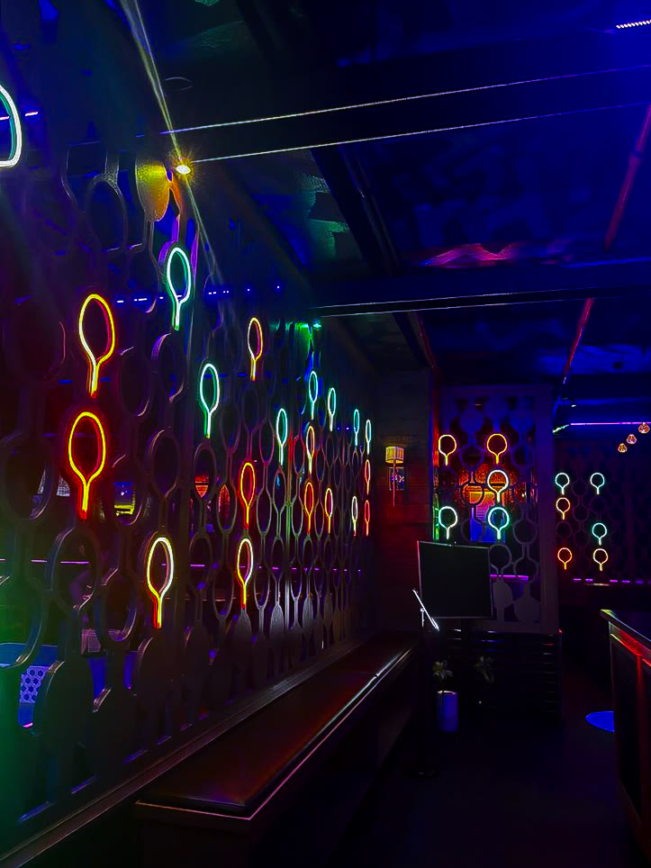 Neon paddle wall corridor inside Space Ping Pong
