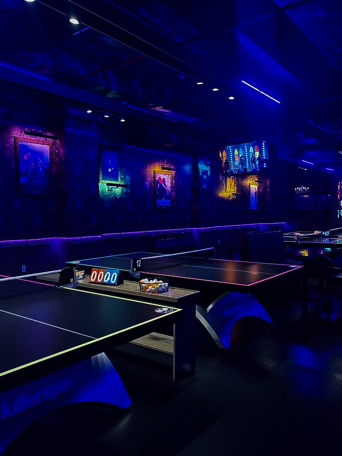 Space Ping Pong tables and lounge under neon lighting